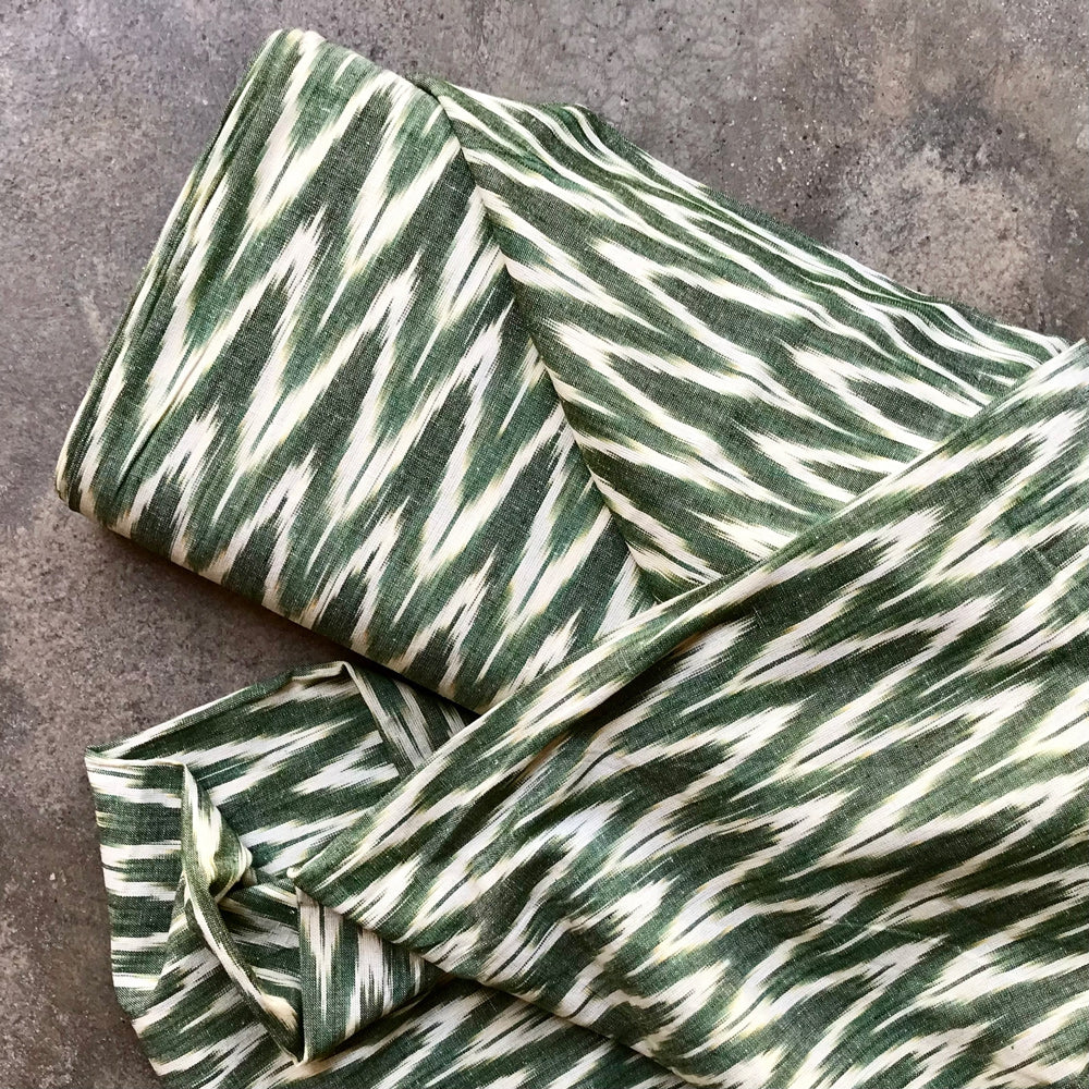 Ikat 4724124 Green and white striped fabric on a textured surface