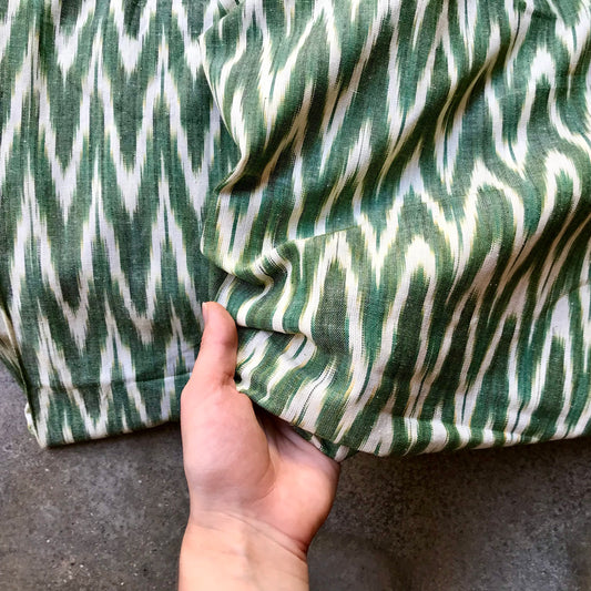 Ikat 4724124 Green and white striped fabric on a textured surface