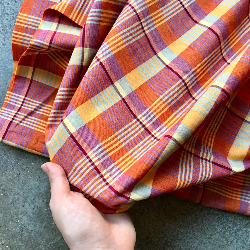 Madras 326125 - Plaid fabric with orange, red, and yellow pattern on a gray surface