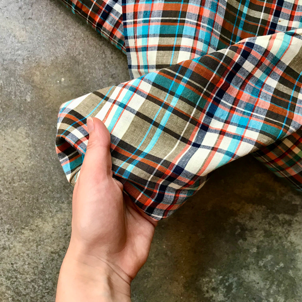 Madras 642417 - Folded plaid fabric with multicolor pattern on a concrete surface