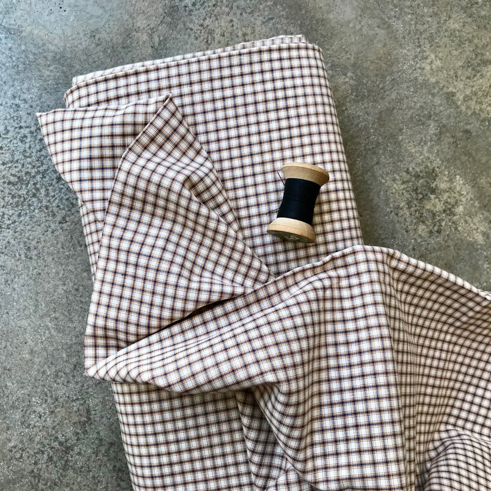 A folded piece of brown and beige gingham fabric 