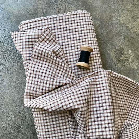 A folded piece of brown and beige gingham fabric 