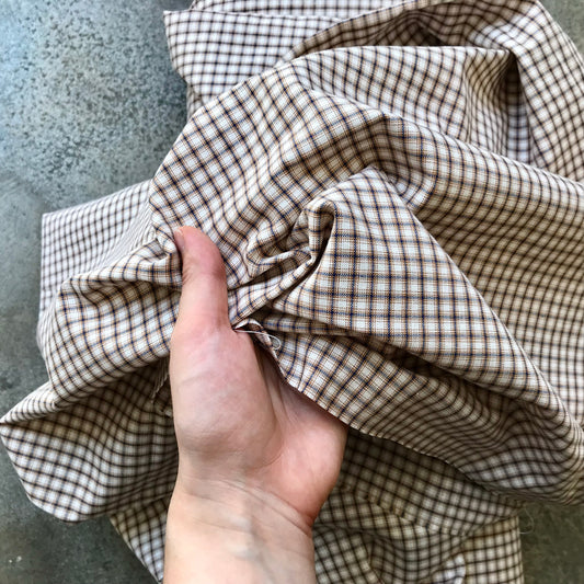 A folded piece of brown and beige gingham fabric 