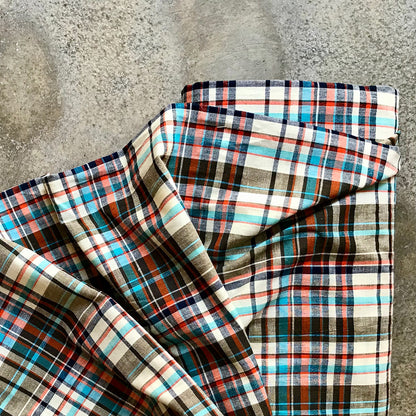 Madras 642417 - Folded plaid fabric with multicolor pattern on a concrete surface