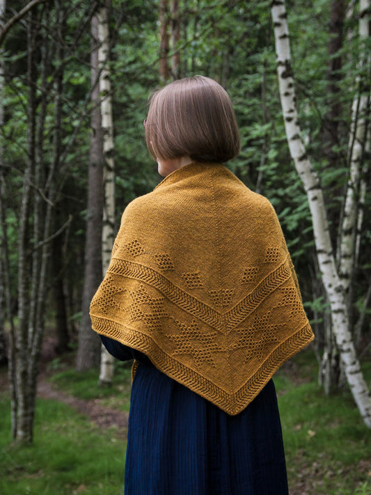 Oisin shawl in Mondim B580, featuring textured geometric patterns and a tassel detail.