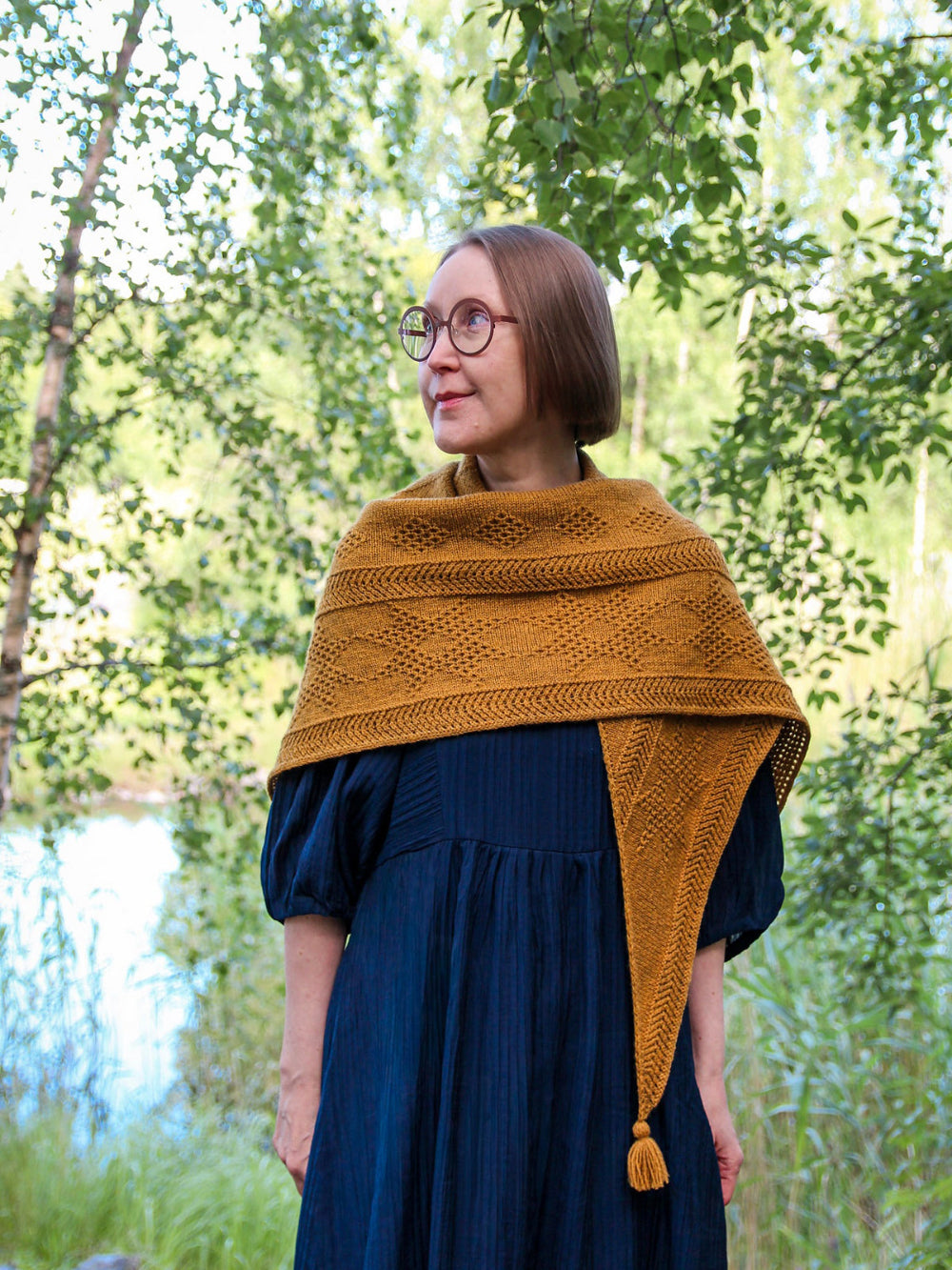 Oisin shawl in Mondim B580, featuring textured geometric patterns and a tassel detail.