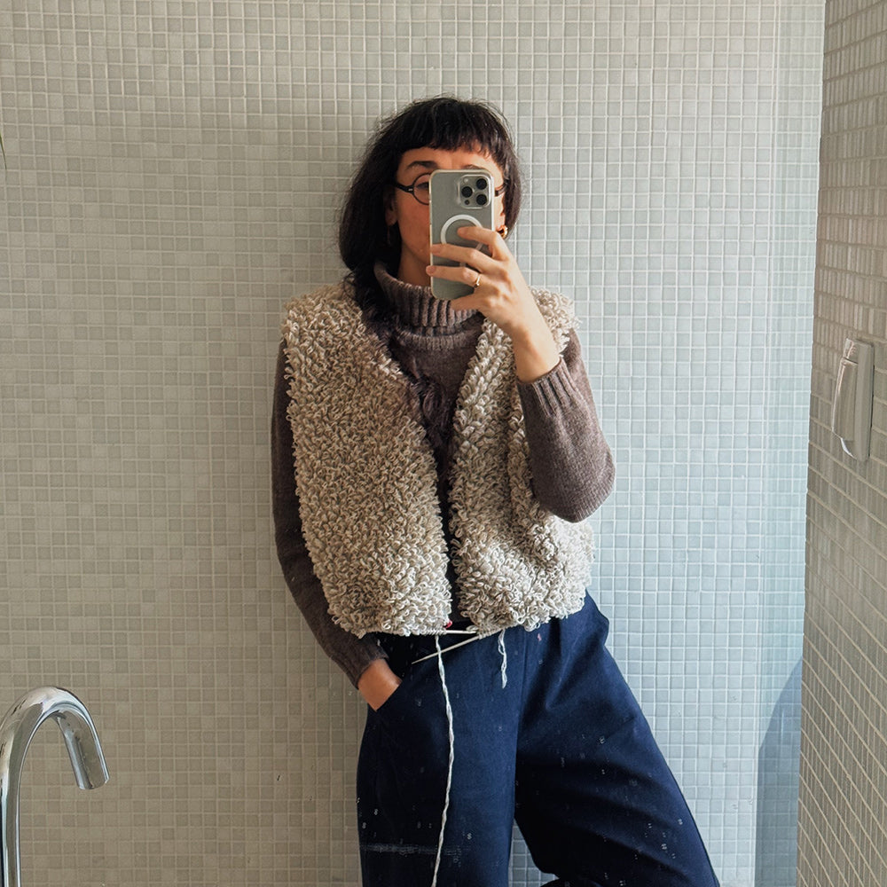 Samarra vest in size 3. Person wearing a textured handknitted wool vest taking a mirror selfie.