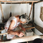 Woman weaving on a traditional loom in a rustic setting